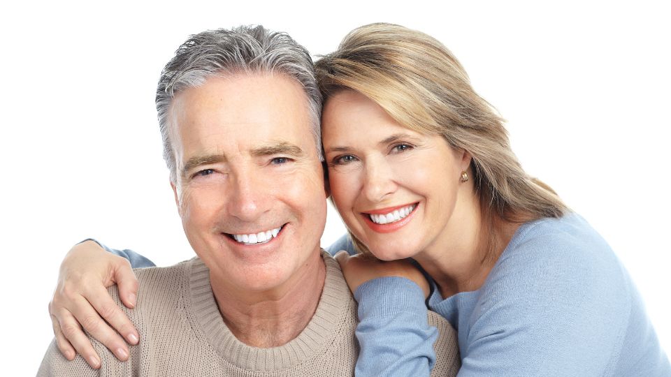 Elderly Couple Smiling After Getting Dental Implants