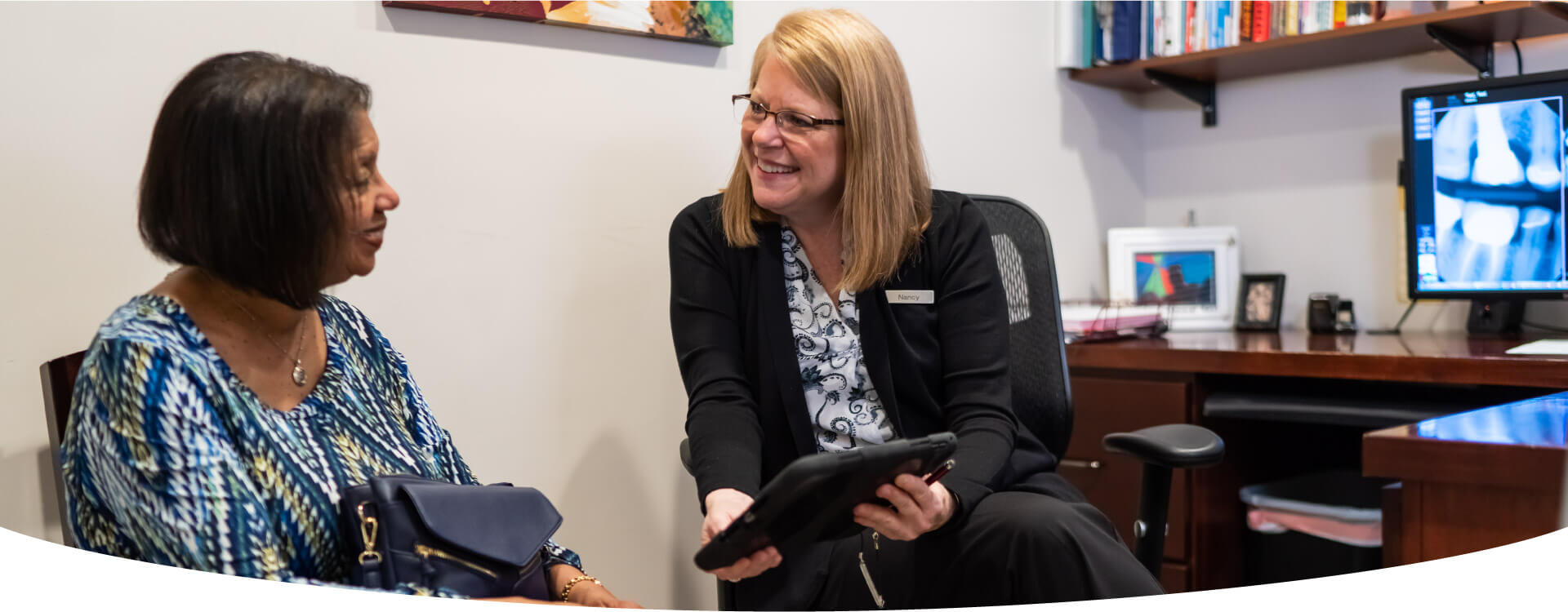 Orthodontics Holding Tab In Hand And Discussing With Patient