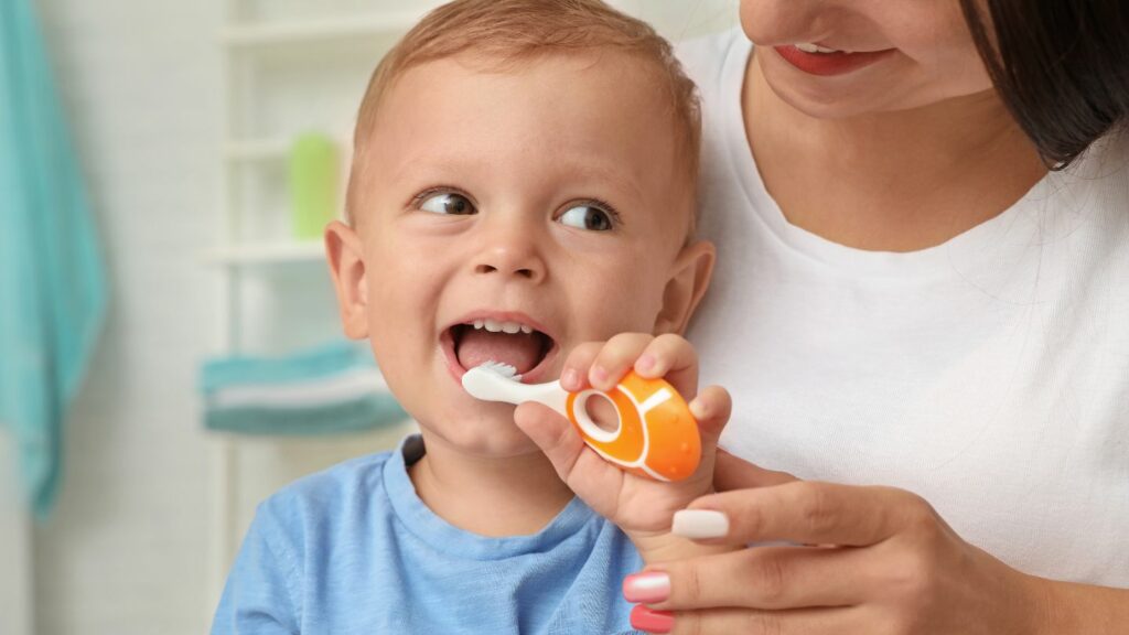 Baby Brushing His Teeth With The Guidance Of His Mom