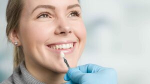 Women Smiling While Getting Veneers By The Dentist