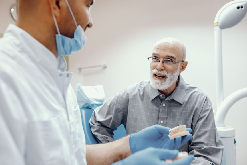 Dentist Holding A Denture Model