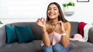 Woman Smiling and Holding Invisalign