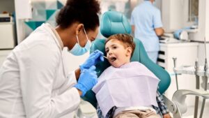 Family Dentist Examining A Child's Teeth